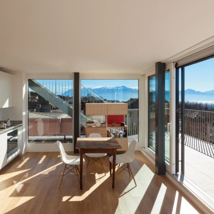 Cuisine moderne et lumineuse avec de grandes fenêtres offrant une vue panoramique – exemple d'aménagement valorisant un bien immobilier grâce aux fenêtres performantes.