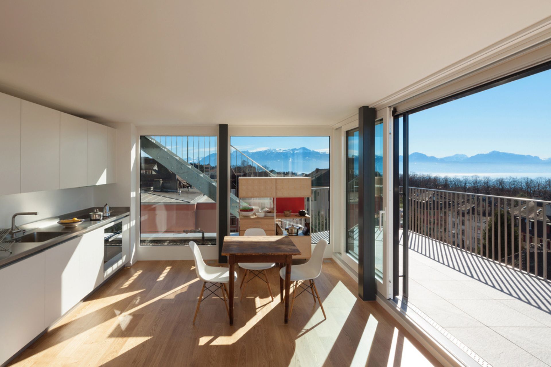 Cuisine moderne et lumineuse avec de grandes fenêtres offrant une vue panoramique – exemple d'aménagement valorisant un bien immobilier grâce aux fenêtres performantes.